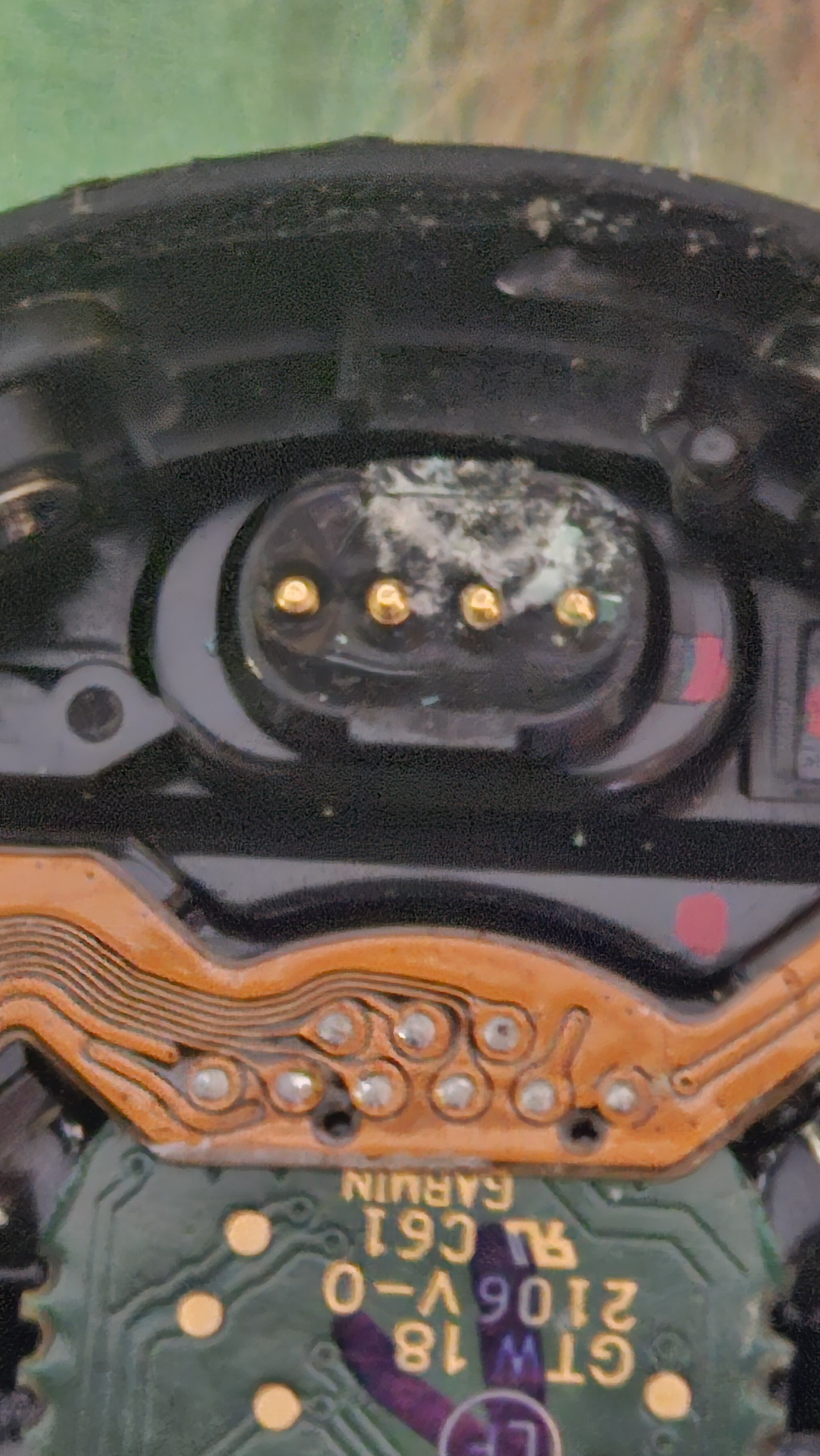 Watch back opened showing corroded contacts